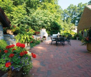 The patio was expanded during the renovation to provide more space for outdoor dining and entertaining. The fireplace was added, as was a retaining wall that unites this space and the pool area.  