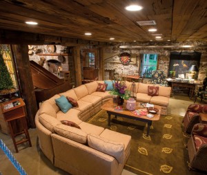 Kerry implemented his idea to transform the mill’s first floor (half of which was once a garage) into a welcoming gathering place. The ceiling is lined with reclaimed pecky cypress. Two of the three posts are original to the space (Ben Graybill created the look-alike replacement). Kerry’s ploy obviously worked. Visitors to his home tend to end up at the mill. Note the reproduction Indian door and the original fireplace.  