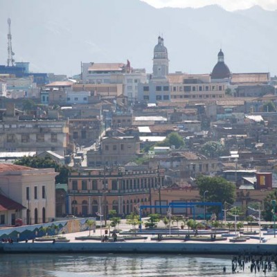 This view of Santiago de Cuba was taken as our ship was coming into the harbor. A park-like plaza can be seen in the foreground. The twin spires of the Cathedral of Our Lady of the Assumption, which is located in the town center, can be seen toward the top center of the photo.