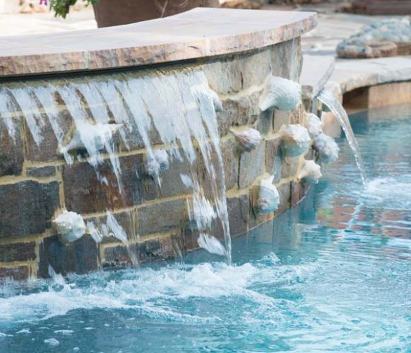 The outdoor-living area also has a shell theme. Masons from Vintage Stone devised a way to incorporate shells into the walls of the pool.
